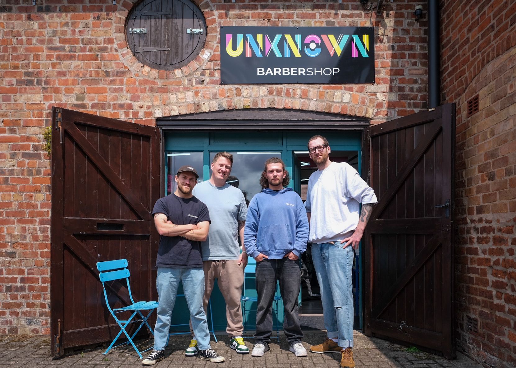 The Unknown Barbershop team outside the barn doors at Harlescott Barns