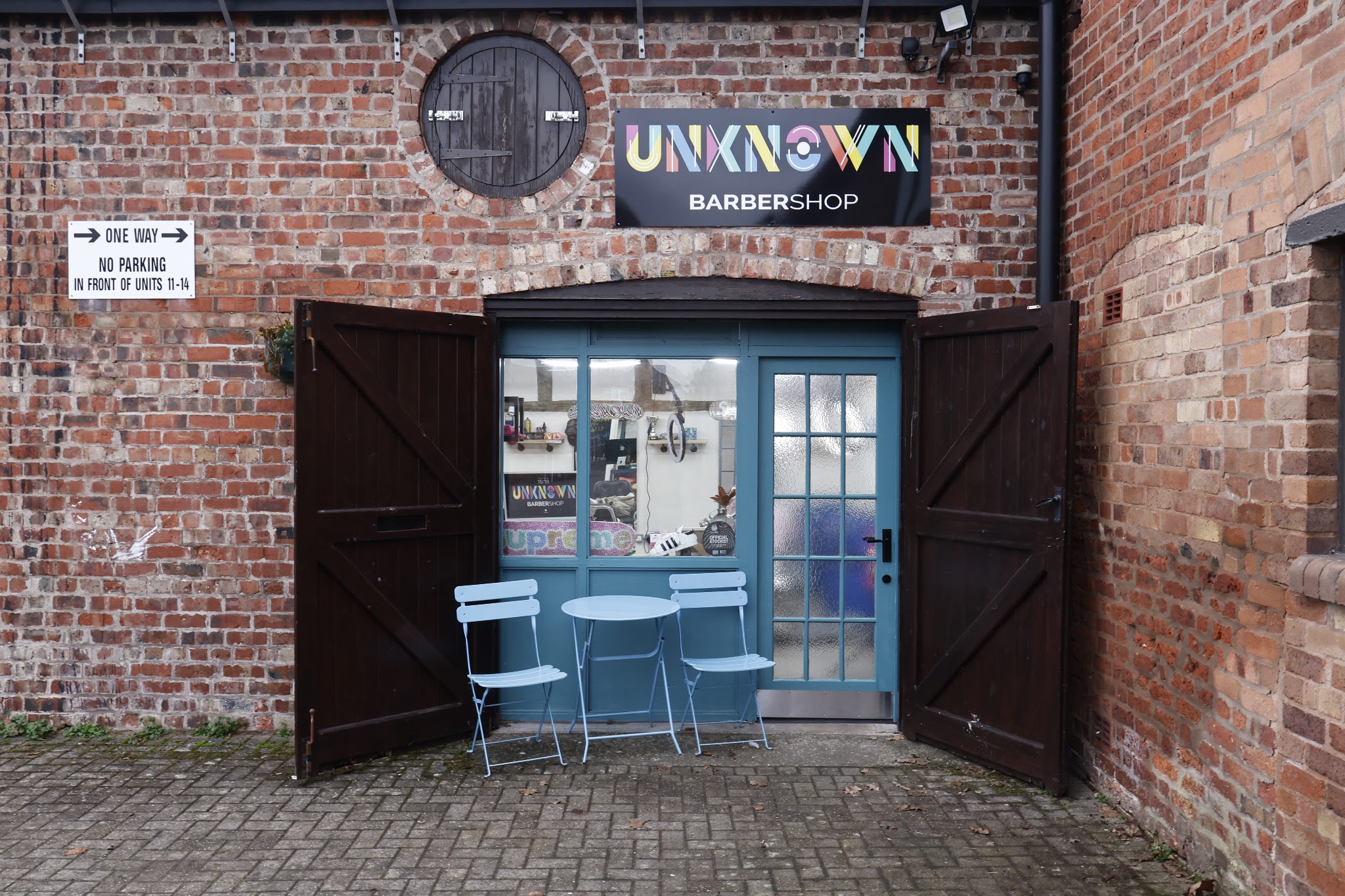 The shopfront with its barn doors open and bistro chairs outside